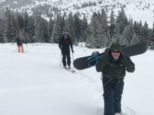 Ken Pishna hiking up Boreas Pass with snowboard