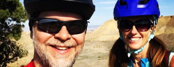 Kenny and April smiling and posing in their mountain biking gear in North Fruita Desert Colorado