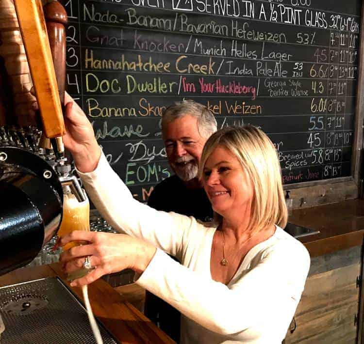 Doc and Stephanie pouring a beer from the taps at Omaha Brewing in Omaha Georgia