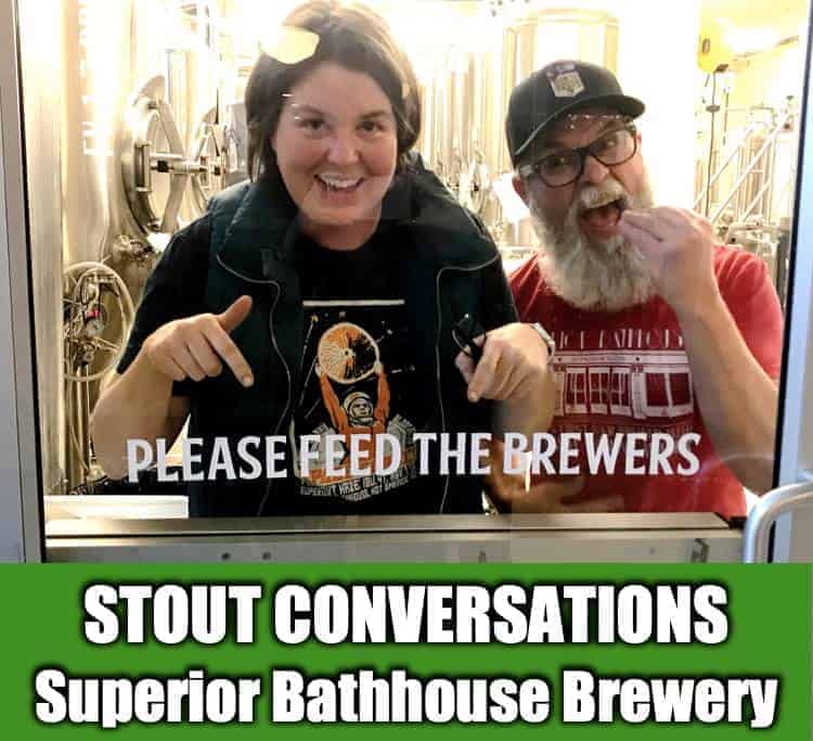 Rose and Jimm of Superior Bathhouse Brewery in Hot Springs National Park in Arkansas being silly pointing at a sign that says Please feed the brewers