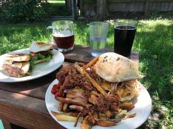 burgers and fries and craft beer on a table outside at City Acre Brewery, Houston Area brewpub