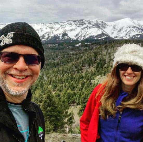 Ken and April posing in front of snow capped mountains outside of Bozeman Montana