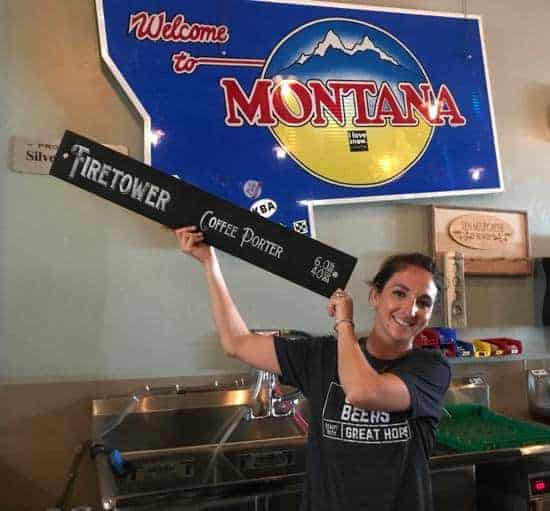 Karli the beertender holding up a new craft beer sign at Ten Mile Creek Brewery