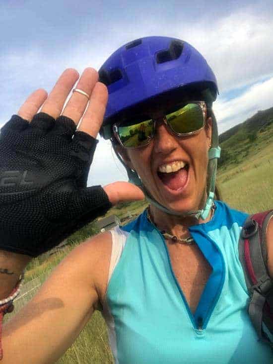 April offering a high five to the camera while in biking gear