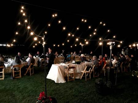 shared tables and lights with people set to eat on the ranch in Yuma Arizona for a Sunset on the Ranch Dinner