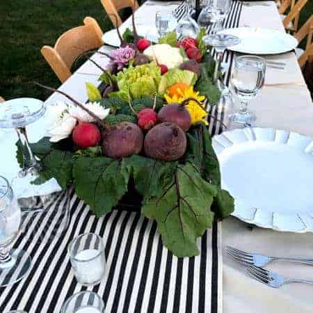 empty shared table beautifully set with fresh vegetables as a centerpiece for the sunset dinner on the ranch in yuma arizona