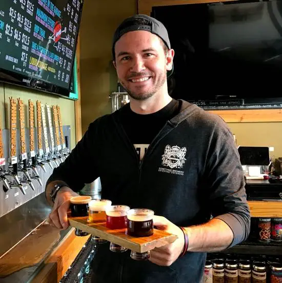 David holding a flight of beers at Something Brewery in Brighton Colorado