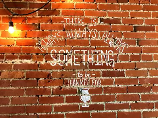 A sign on a brick wall at Something Brewery in Brighton Colorado stating There's always something to be thankful for