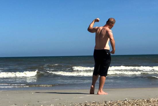 Ken on beach in Jacksonville Florida posing for a fitness shot staying fit while traveling