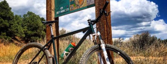 MTB in Durango at Horse Gulch - Ken's bike Frankie leaning up against trail map