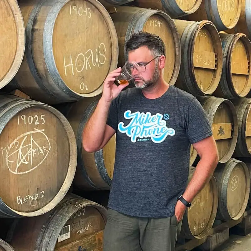 Mike at Mikerphone smelling beer in front of barrels Illinois