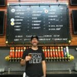 Adam Mills holding beer behind bar Cartridge Brewing Ohio