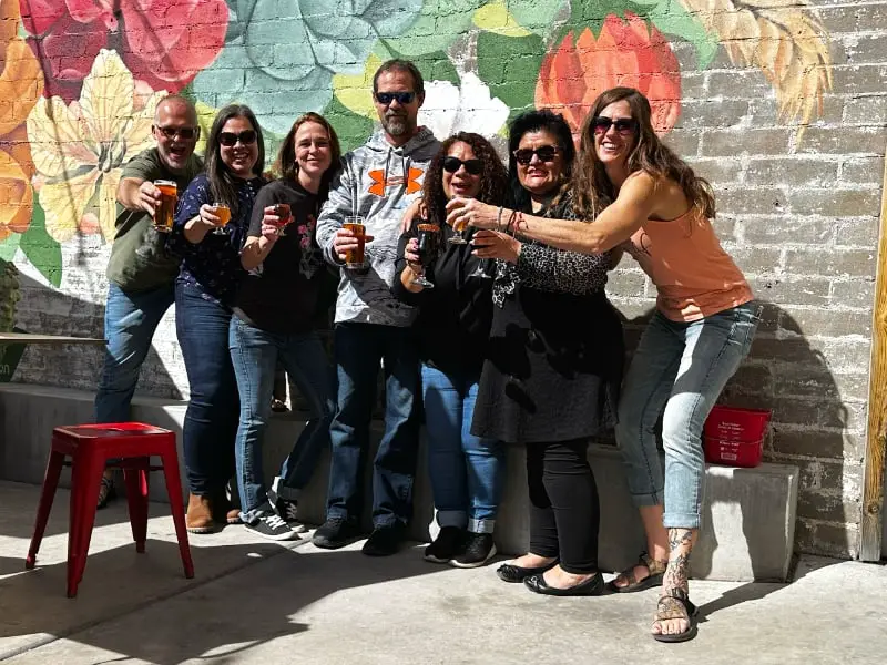 group of people cheers outdoor brewery patio Arizona