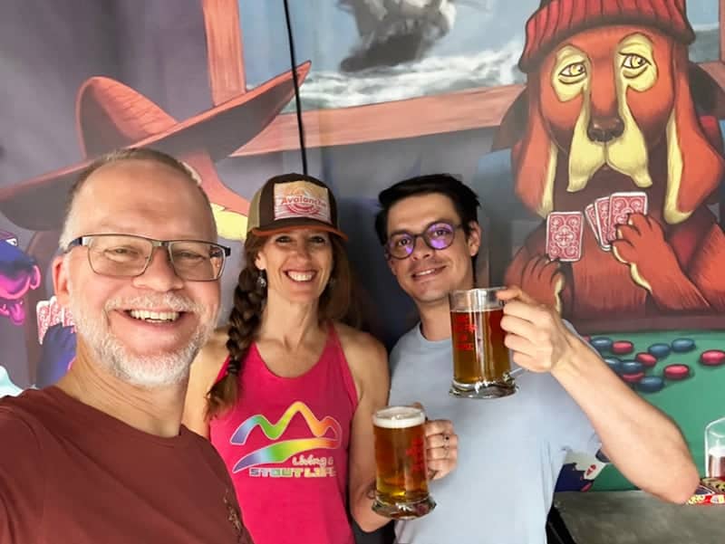 Julian Ken April with beer in front of dog mural at ÖlBröder in Medellín Colombia a craft brewery in Medellín