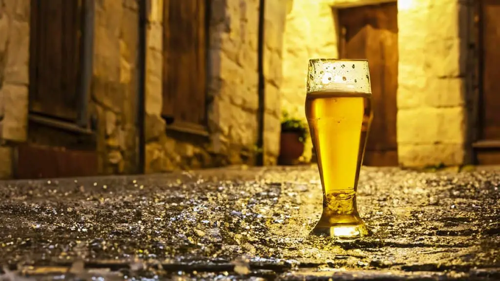 glass of beer on cobblestone street cover