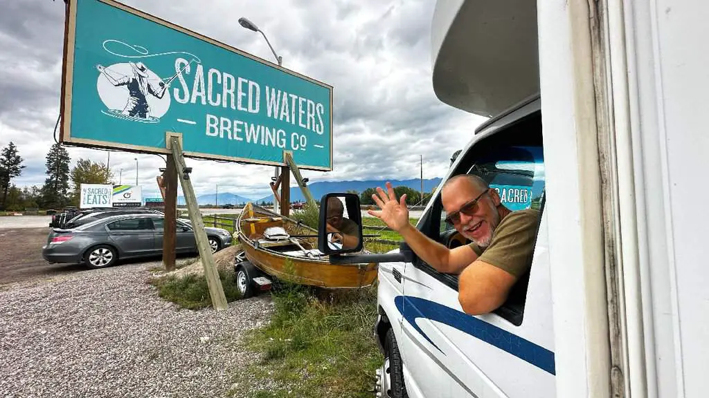 Kenny in RAIF RV waving at Sacred Waters Harvest Hosts Montana