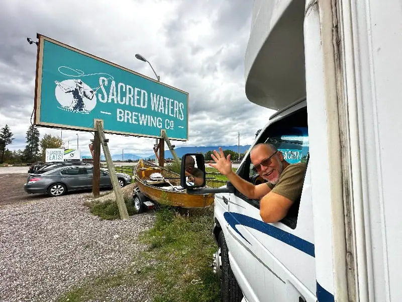 Kenny in RAIF RV waving at Sacred Waters Harvest Hosts Montana